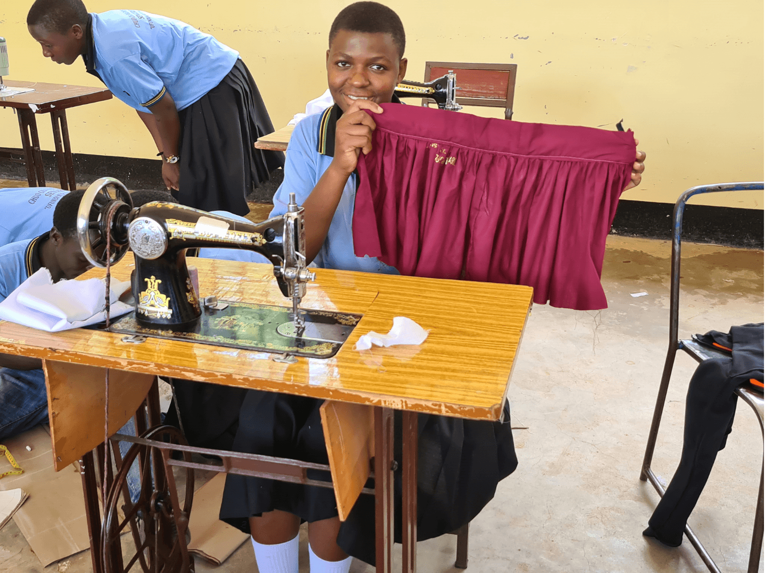 Graduate displaying completed tailored garment