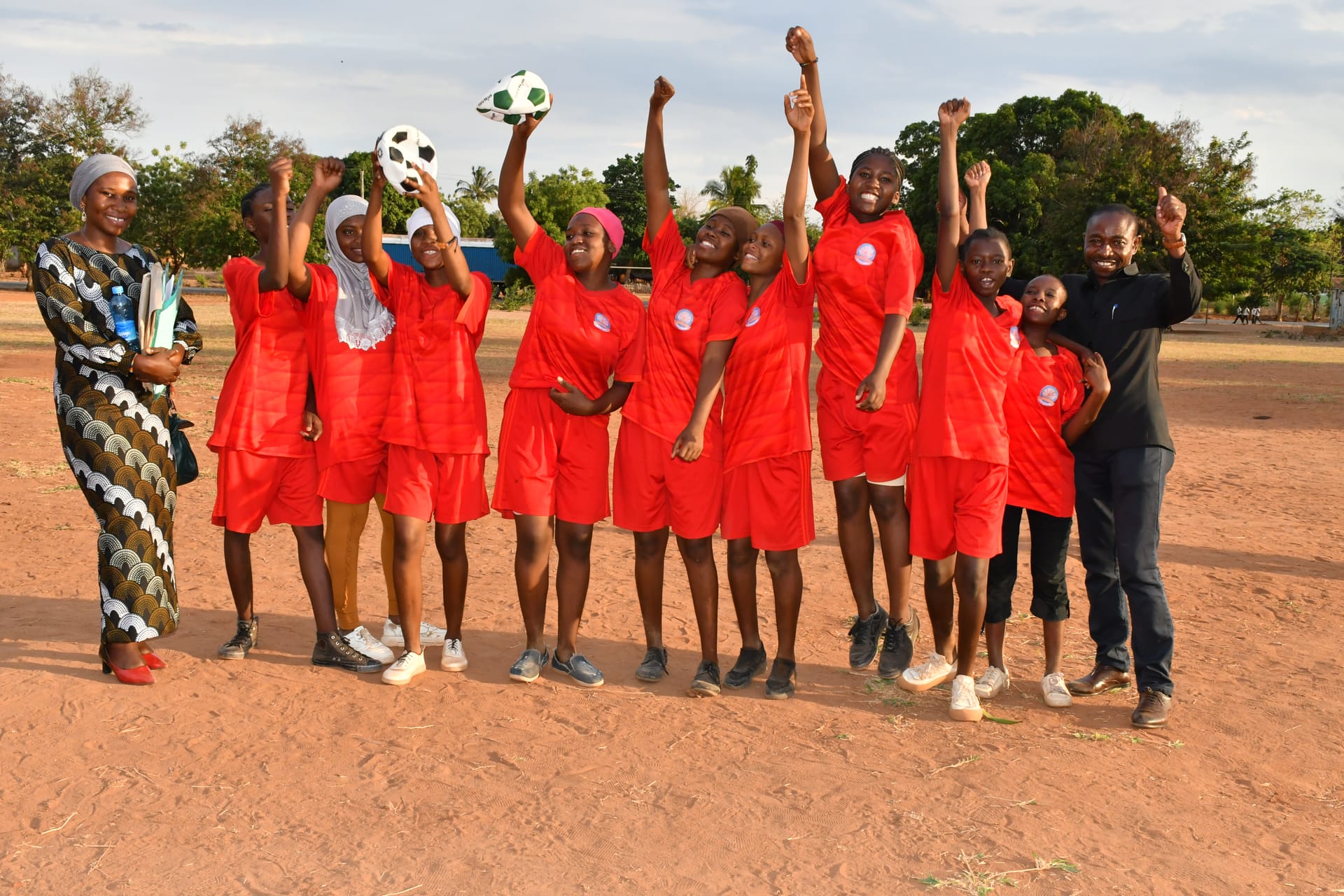 Girls' football team celebrating after a Mpira Fursa match